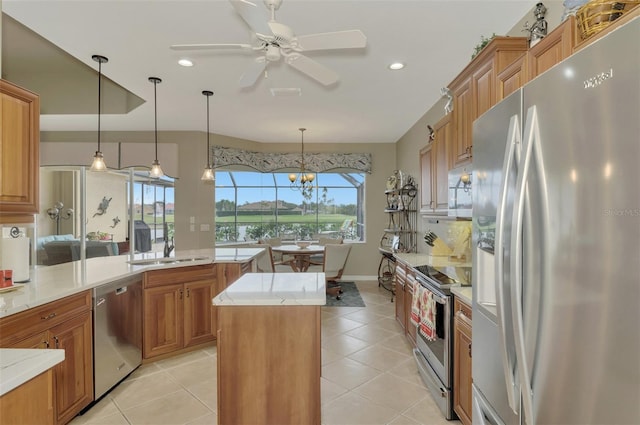 kitchen with ceiling fan with notable chandelier, a center island, decorative light fixtures, stainless steel appliances, and light tile patterned floors