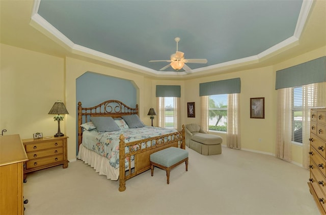 bedroom featuring ceiling fan, crown molding, light carpet, and a raised ceiling