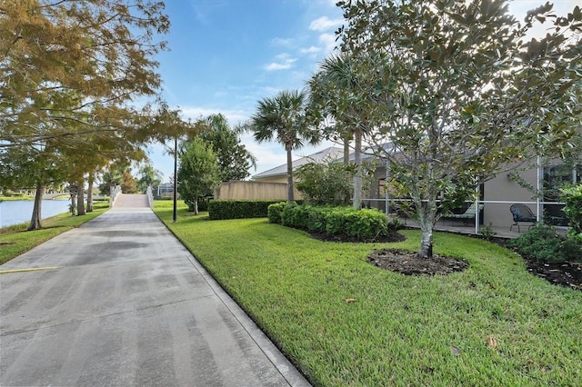 view of community with a lawn and a water view