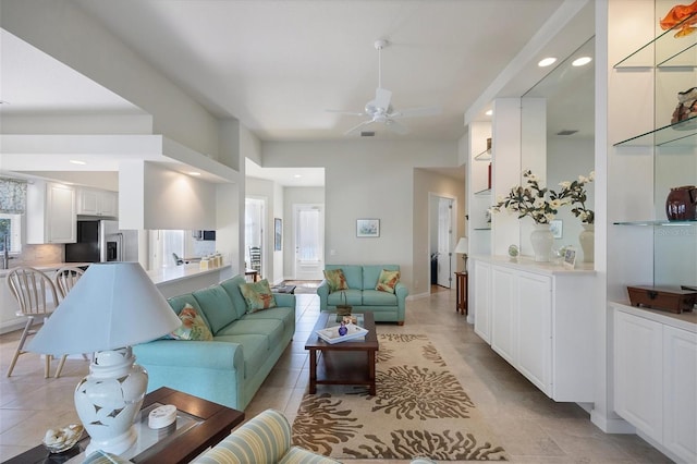 tiled living room featuring ceiling fan and a wealth of natural light