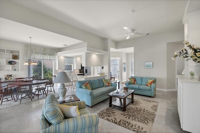 living room with ceiling fan with notable chandelier and light tile patterned flooring