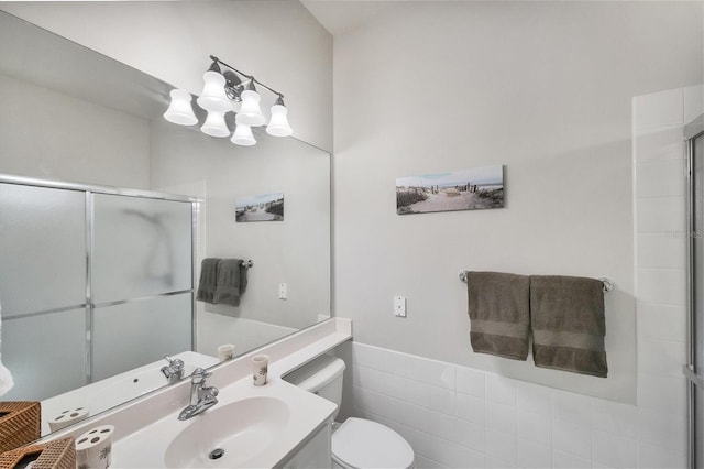 bathroom with tile walls, toilet, walk in shower, vanity, and an inviting chandelier