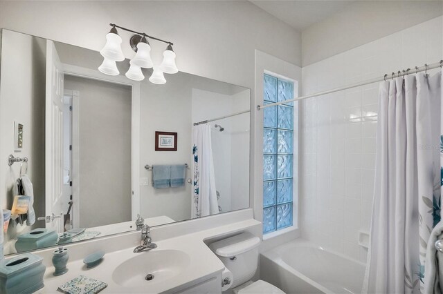 full bathroom featuring vanity, toilet, a chandelier, and shower / bath combo