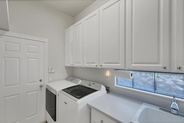 laundry area with sink, separate washer and dryer, and cabinets