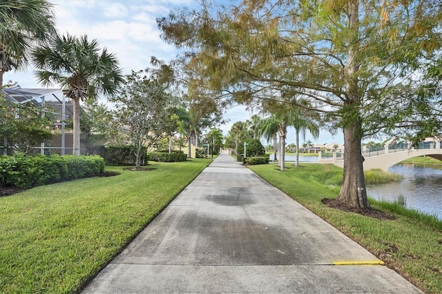 view of property's community with a lawn and a water view