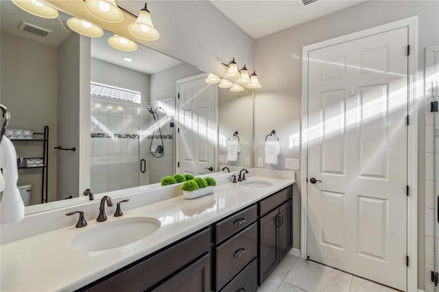 bathroom featuring vanity, a shower with door, and tile patterned flooring