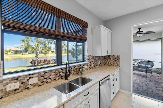 kitchen with sink, a water view, tasteful backsplash, white cabinets, and stainless steel dishwasher