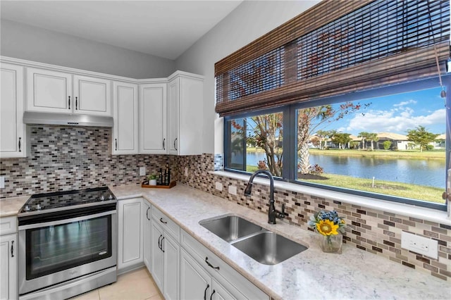 kitchen featuring stainless steel electric range oven, white cabinetry, sink, decorative backsplash, and a water view