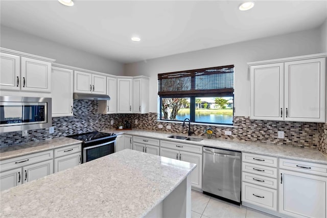 kitchen featuring sink, light tile patterned floors, white cabinetry, backsplash, and stainless steel appliances