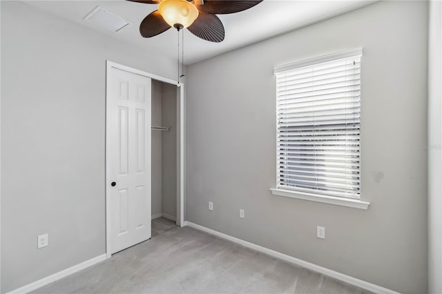 unfurnished bedroom with ceiling fan, light colored carpet, and a closet