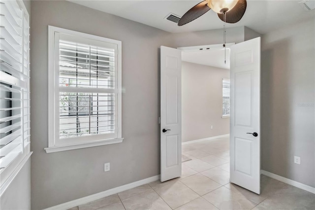 unfurnished room with ceiling fan and light tile patterned floors