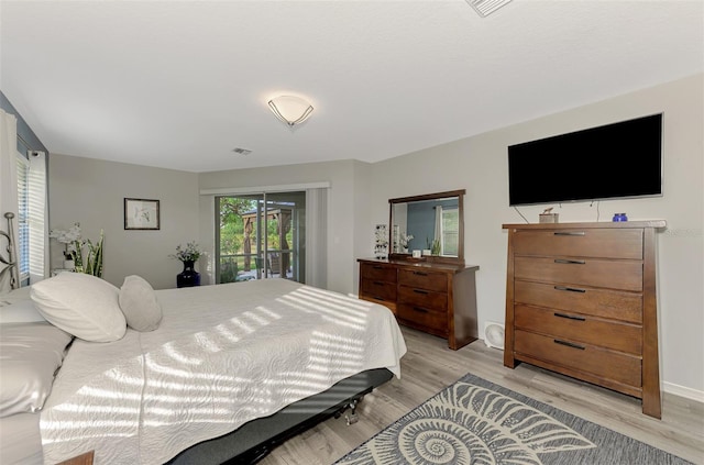 bedroom with light wood-type flooring and access to outside