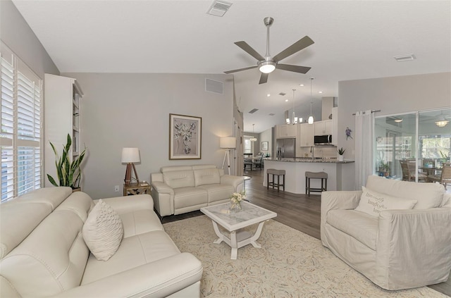 living room with lofted ceiling, hardwood / wood-style floors, and ceiling fan