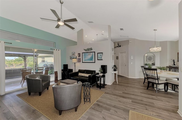 living room with light hardwood / wood-style flooring, high vaulted ceiling, and ceiling fan