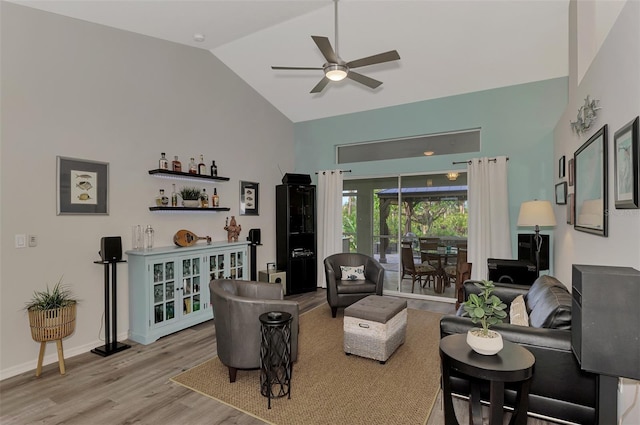 living room with ceiling fan, lofted ceiling, and light hardwood / wood-style floors