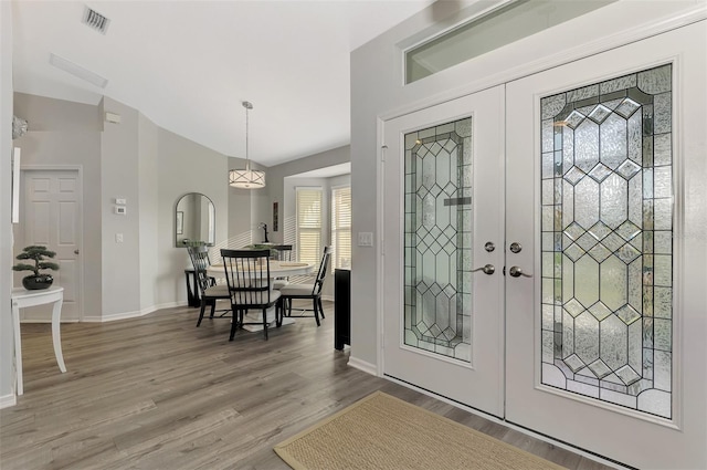 entryway featuring hardwood / wood-style flooring, lofted ceiling, and french doors