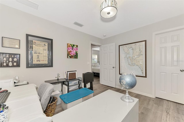 home office with light hardwood / wood-style floors