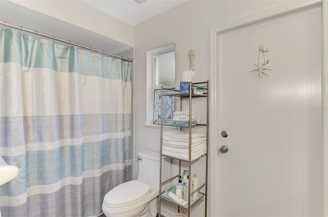 bathroom with curtained shower and toilet