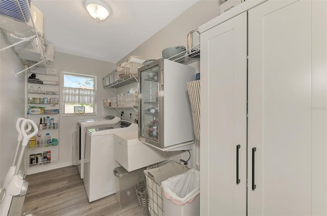 washroom with hardwood / wood-style flooring and washing machine and dryer