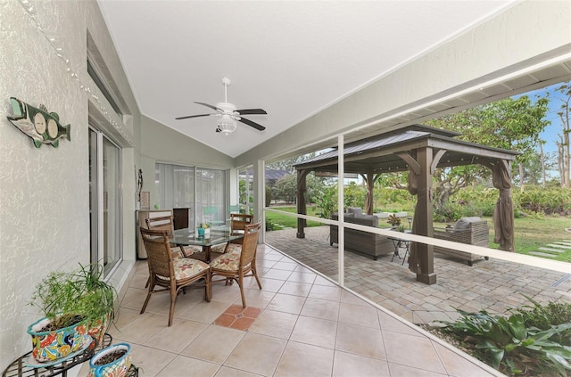 sunroom with ceiling fan and vaulted ceiling