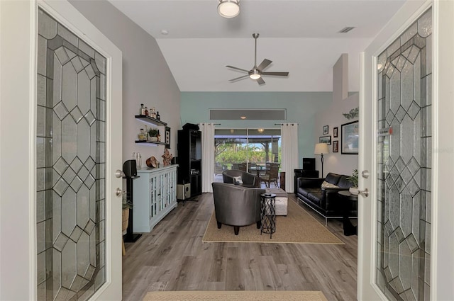 living room with lofted ceiling, light hardwood / wood-style flooring, french doors, and ceiling fan