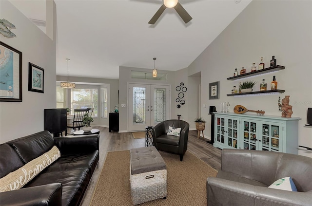 living room featuring french doors, lofted ceiling, ceiling fan, and light hardwood / wood-style flooring