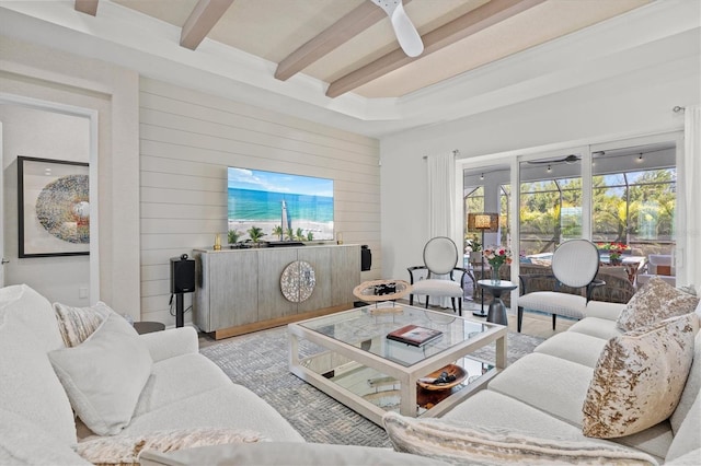 living room featuring beam ceiling, ceiling fan, and wood walls