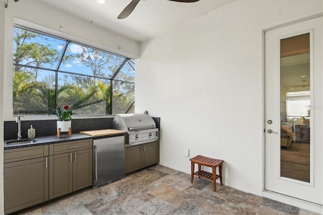 view of patio with sink, a lanai, ceiling fan, grilling area, and an outdoor kitchen