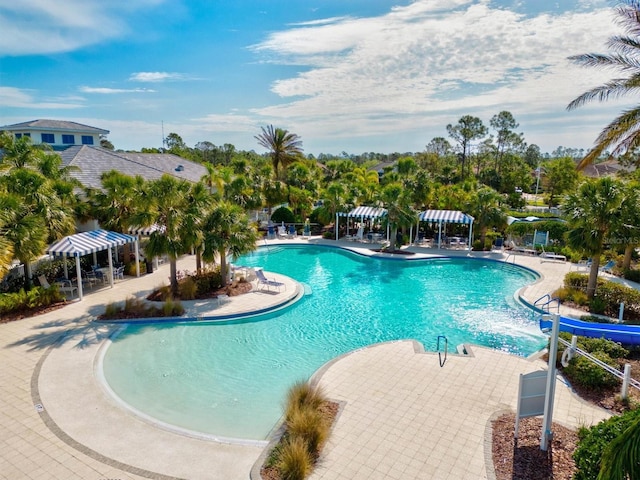 view of swimming pool featuring a water slide and a patio area