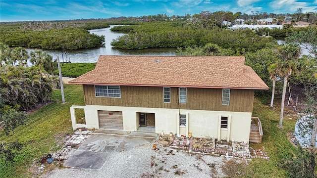 view of front of home with a garage and a water view