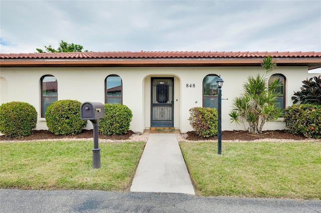 mediterranean / spanish home featuring a front yard