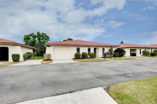 mediterranean / spanish-style house with a garage and a front yard