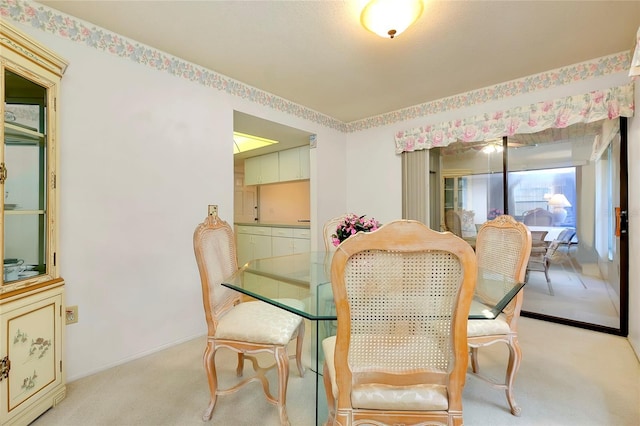 dining space featuring light carpet