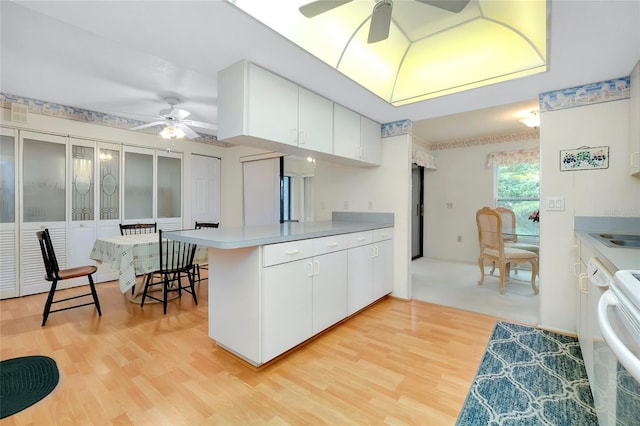 kitchen featuring kitchen peninsula, white cabinetry, light hardwood / wood-style flooring, and ceiling fan