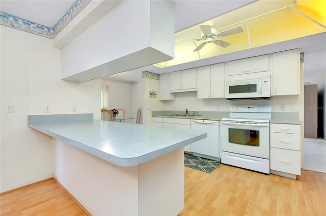 kitchen featuring white appliances, light hardwood / wood-style floors, white cabinets, sink, and kitchen peninsula