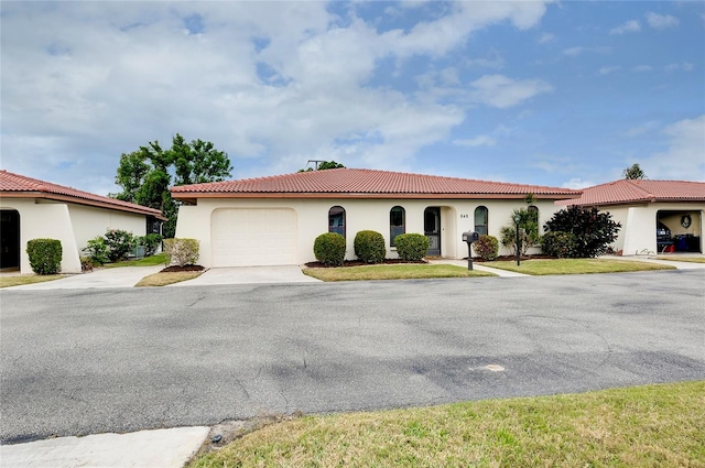 mediterranean / spanish house with a garage and a front yard