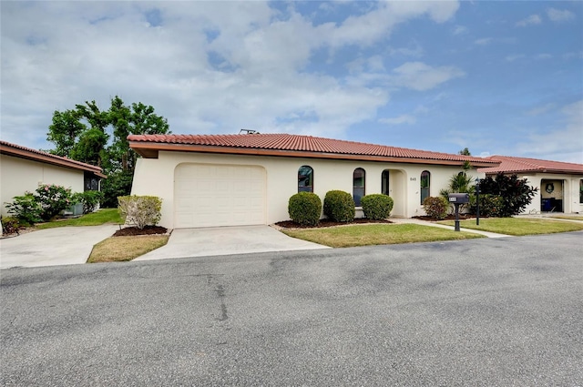 mediterranean / spanish-style house featuring a garage and a front lawn