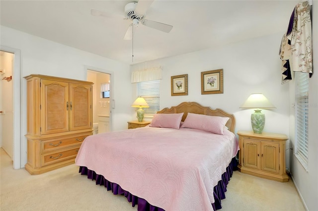 carpeted bedroom featuring ceiling fan and ensuite bath