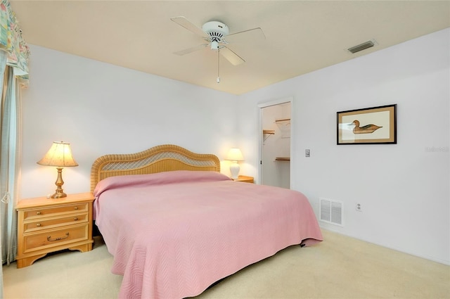 carpeted bedroom with a spacious closet, a closet, and ceiling fan