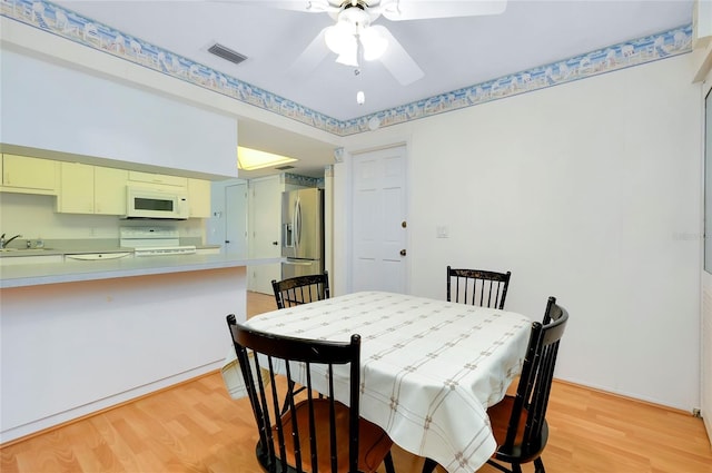 dining room featuring light hardwood / wood-style floors, sink, and ceiling fan