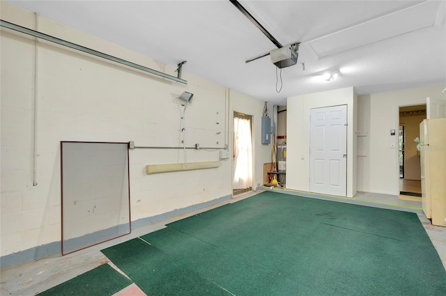 garage with electric panel, white fridge, and a garage door opener