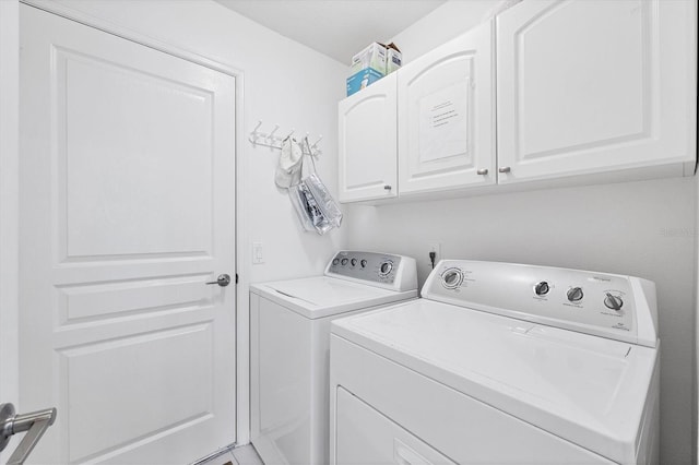 clothes washing area with cabinets and independent washer and dryer