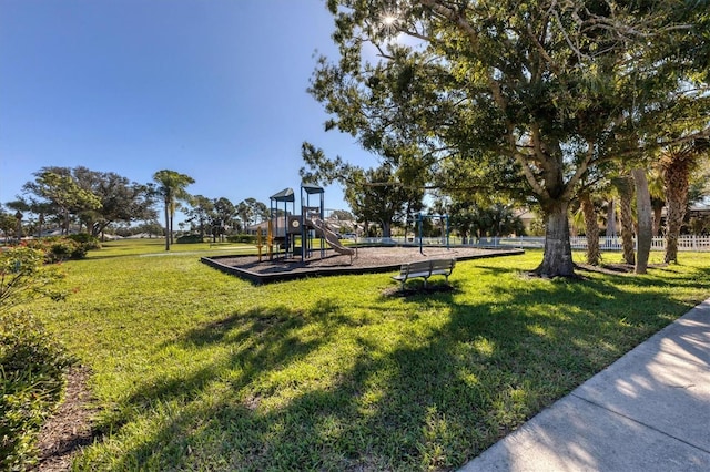 view of property's community featuring a lawn and a playground