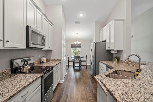 kitchen featuring pendant lighting, sink, appliances with stainless steel finishes, light stone counters, and white cabinets