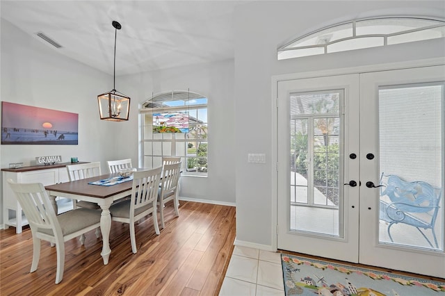 dining room featuring a chandelier, light tile patterned floors, and french doors