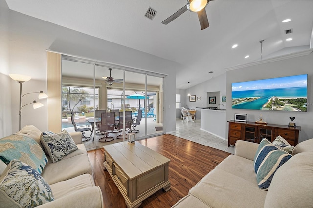 living room with ceiling fan, light tile patterned floors, and lofted ceiling