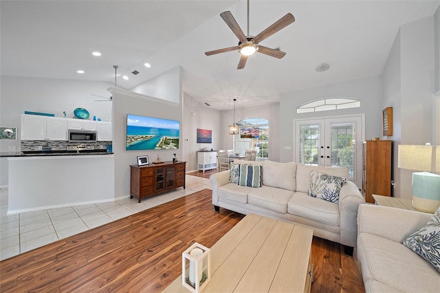 tiled living room featuring ceiling fan, lofted ceiling, and french doors