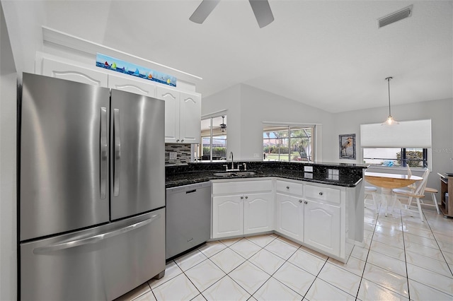 kitchen with pendant lighting, white cabinets, appliances with stainless steel finishes, tasteful backsplash, and sink