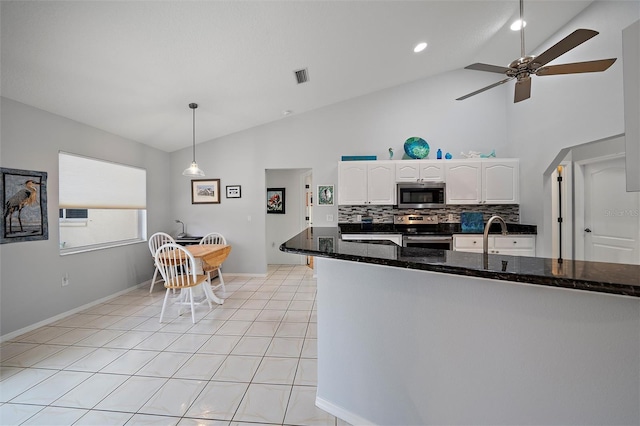 kitchen with white cabinets, decorative light fixtures, stainless steel appliances, dark stone countertops, and backsplash