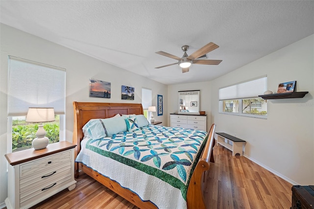 bedroom with ceiling fan, a textured ceiling, and hardwood / wood-style flooring